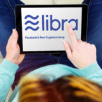 Woman using touch pad with the libra logo, the new crypto currency created by facebook company