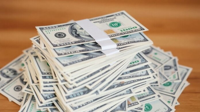 Pile of US dollar bills, some worn, some new.