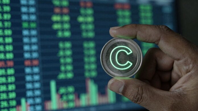 Digital coin with 'C' symbol held in hand.