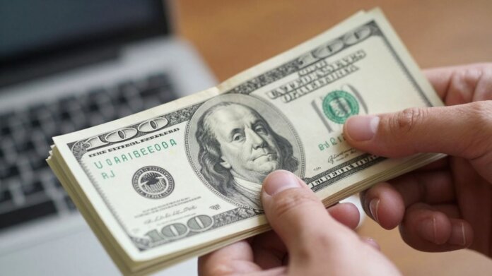 US dollar bills held in hand, financial growth concept.
